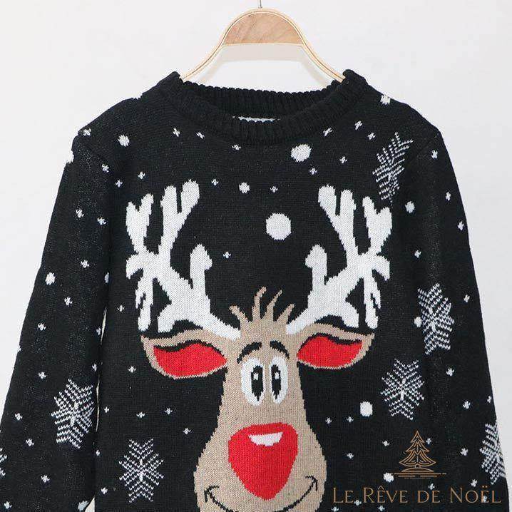 Gros plan du pull de Noël noir à motif de renne souriant et flocons, présenté sur un cintre
