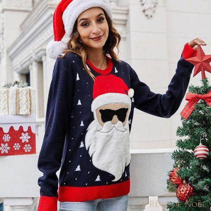Pull de Noël bleu marine à visage de Père Noël à lunettes, porté avec un bonnet rouge en extérieur