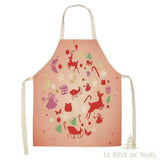 Tablier de cuisine rose avec motifs de Noël (rennes, traîneau, sapins) en cercle, vu de face