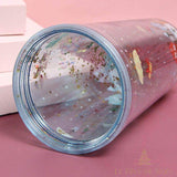 Gobelet pailleté de Noël couché sur le côté, vue sur l'ouverture transparente et les confettis