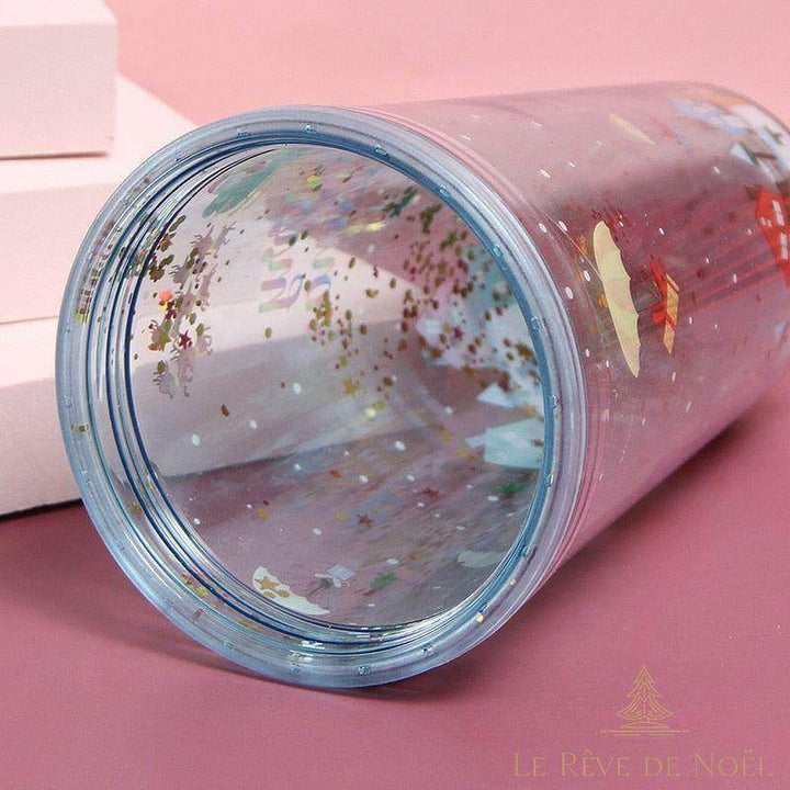 Gobelet pailleté de Noël couché sur le côté, vue sur l'ouverture transparente et les confettis