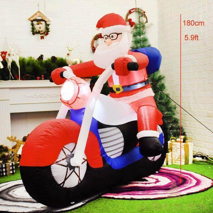 Père Noël gonflable à lunettes sur une moto rouge et noire, phare allumé, dans un salon décoré