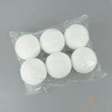 Six boules de Noël enneigées dans un sachet plastique transparent, sur fond gris