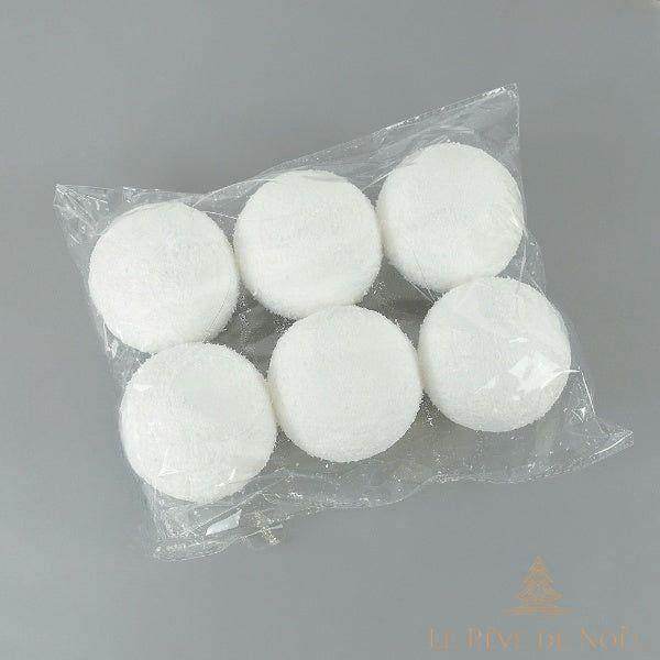 Six boules de Noël enneigées dans un sachet plastique transparent, sur fond gris