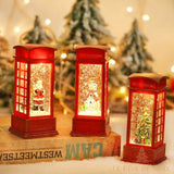 Trois boules à neige cabine téléphonique rouge allumées, Père Noël, bonhomme de neige et sapin