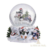 Boule à neige avec trois pingouins et un sapin dans le globe, famille de pingouins sur le socle