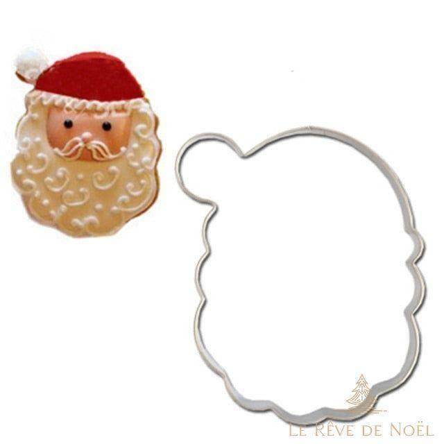 Emporte-pièce métallique en forme de tête de Père Noël, à côté d'un biscuit décoré assorti
