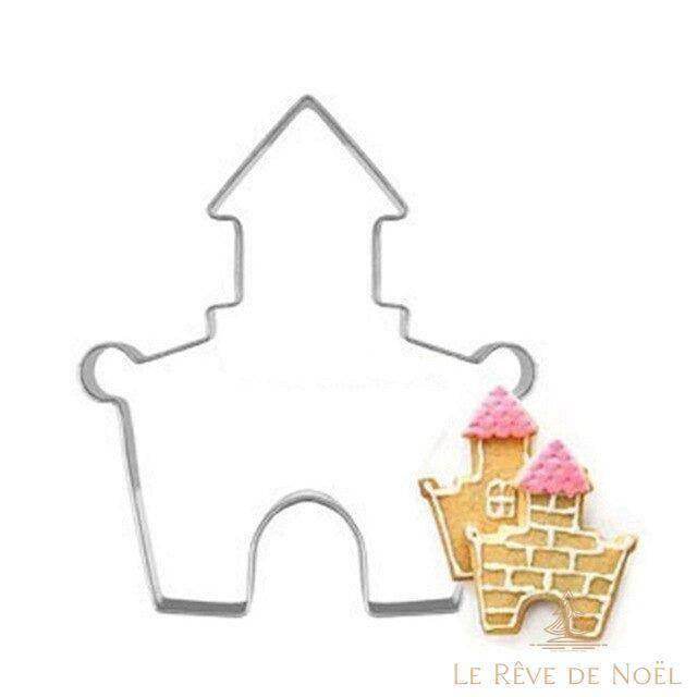Emporte-pièce château en métal, à côté d'un biscuit décoré en briques et toits roses