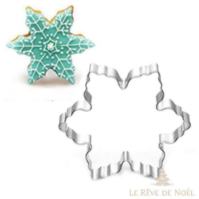 Emporte-pièce flocon en métal, à côté d'un exemple de biscuit glacé turquoise et blanc