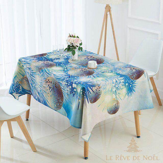Nappe bleu glacier à motif de boules de Noël argentées et branches givrées, dressée avec un bouquet