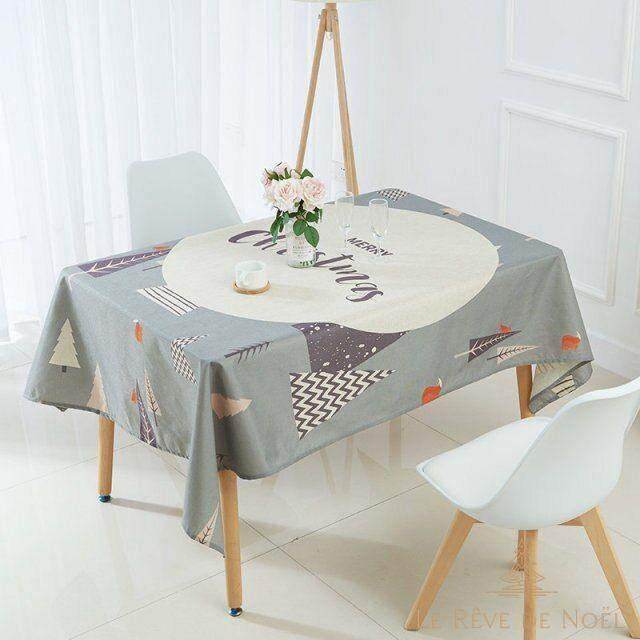 Nappe de Noël grise à motifs de sapins et pois, dressée sur une table avec bouquet de roses