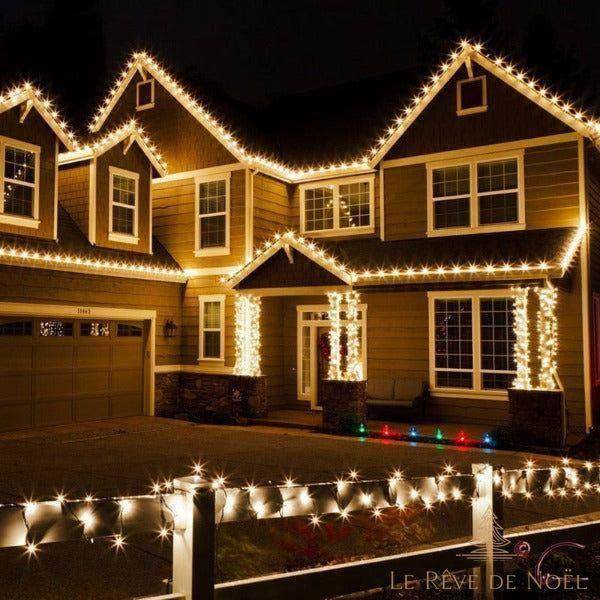 Guirlande lumineuse blanc chaud installée sur la façade et le toit d'une maison, la nuit