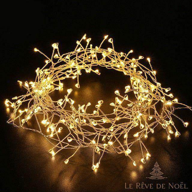 Guirlande lumineuse enroulée, allumée en blanc chaud, sur fond noir