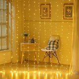 Rideau lumineux blanc chaud allumé du sol au plafond dans une chambre, avec chaise et commode