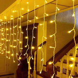 Rideau lumineux blanc chaud installé près d'un escalier, gros plan sur les fils et LED