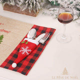 Porte-couvert Père Noël rouge à pompon blanc, couverts insérés sur un set de table à carreaux