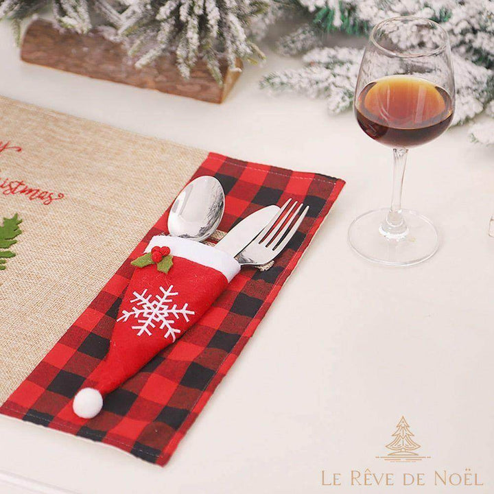Porte-couvert Père Noël rouge à pompon blanc, couverts insérés sur un set de table à carreaux