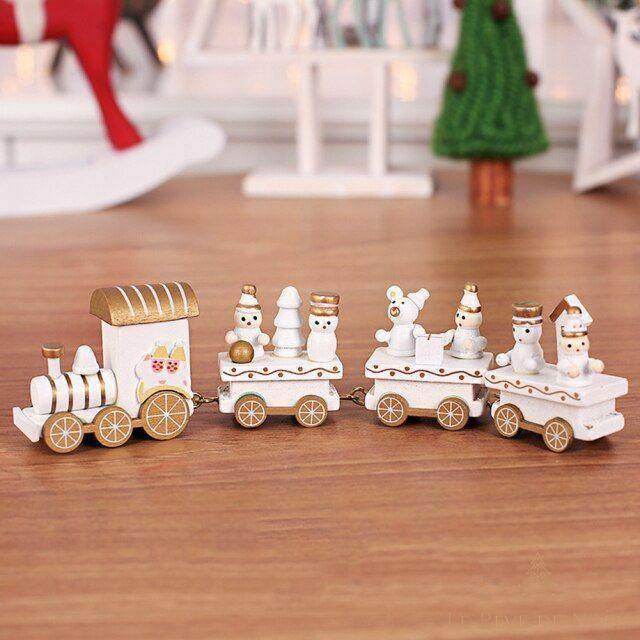 Train de Noël miniature en bois blanc et doré avec figurines de bonhommes de neige, sur une table