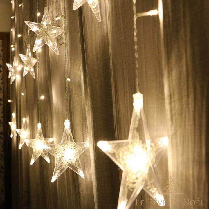 Guirlande lumineuse étoiles transparentes blanc chaud, suspendue devant un rideau voilé